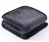 Folded gray microfiber towel with black edges on a white background